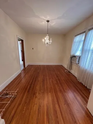 a view of a room with wooden floors and chandelier