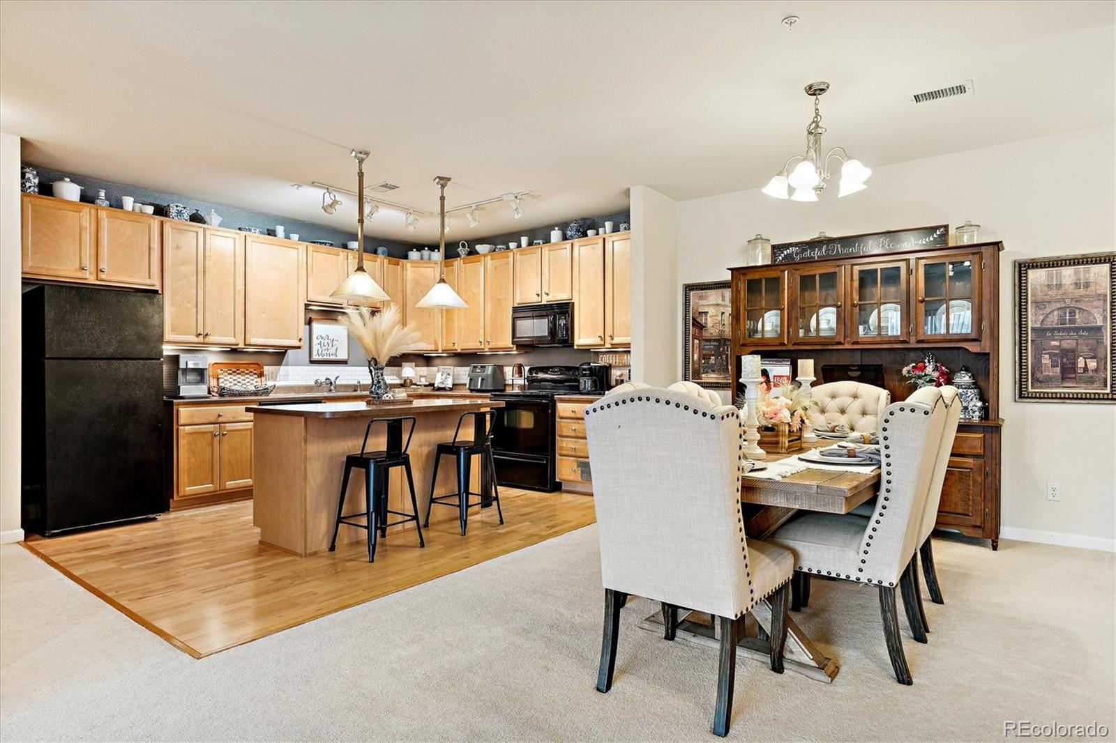 9370 Las Ramblas Court, Unit R Parker, CO 80134 - Photo 11 of 39 a dining room with stainless steel appliances kitchen island granite countertop a table chairs and a refrigerator