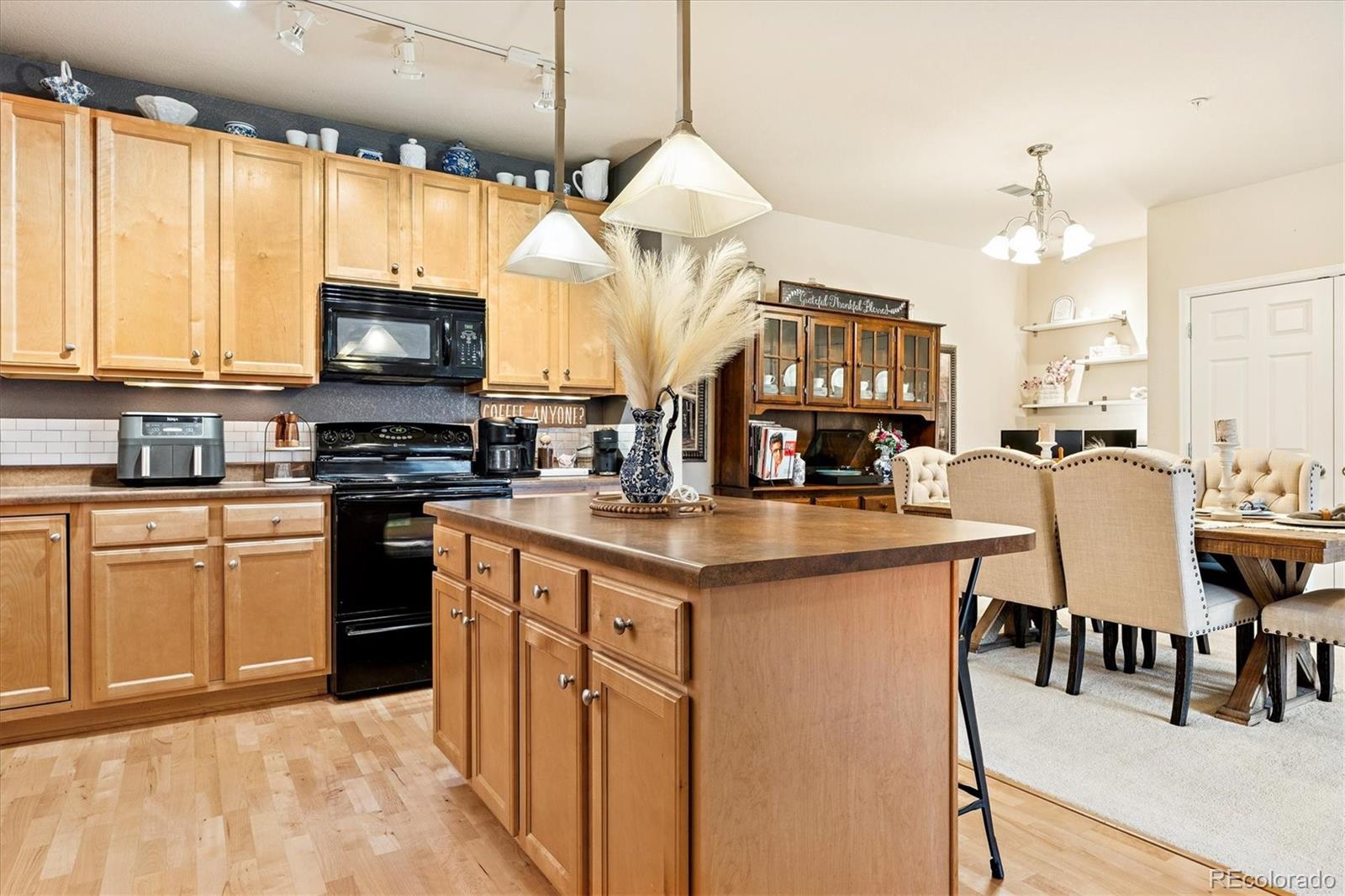 9370 Las Ramblas Court, Unit R Parker, CO 80134 - Photo 15 of 39 a kitchen with stainless steel appliances granite countertop a stove top oven a sink dishwasher a dining table and chairs with wooden floor