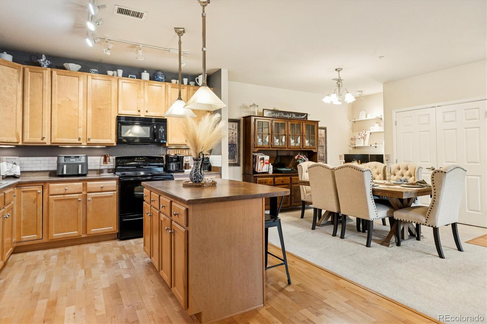 9370 Las Ramblas Court, Unit R Parker, CO 80134 - Photo 16 of 39 a open kitchen with stainless steel appliances granite countertop a stove top oven a sink dishwasher a dining table and chairs with wooden floor