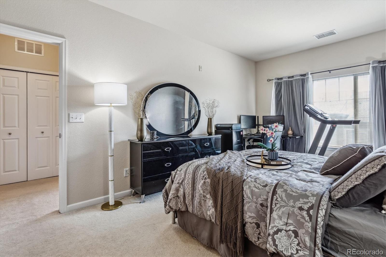 9370 Las Ramblas Court, Unit R Parker, CO 80134 - Photo 23 of 39 a bedroom with a bed a dresser and a large mirror