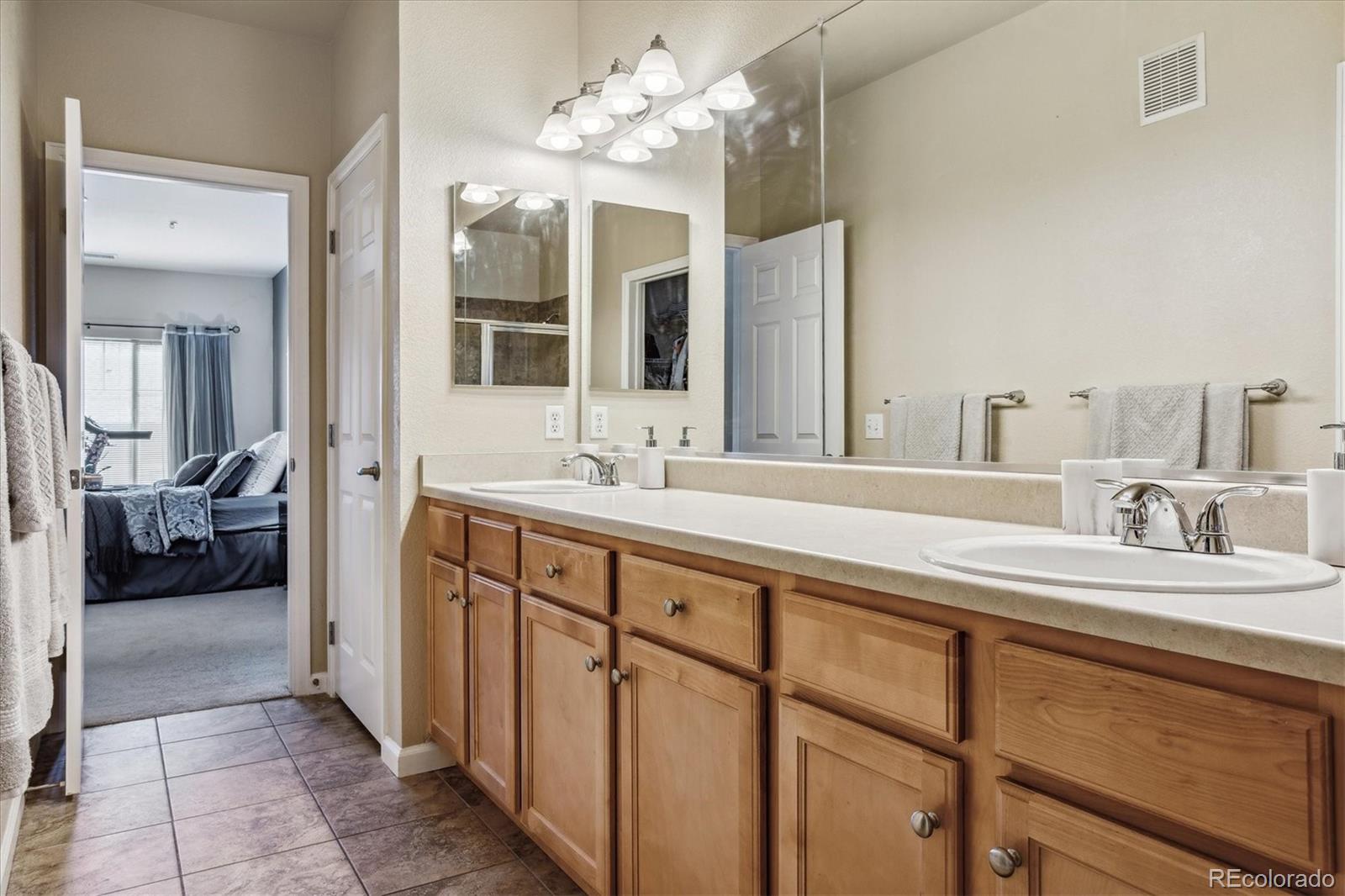 9370 Las Ramblas Court, Unit R Parker, CO 80134 - Photo 25 of 39 a en suite bathroom with a double vanity sink and a mirror