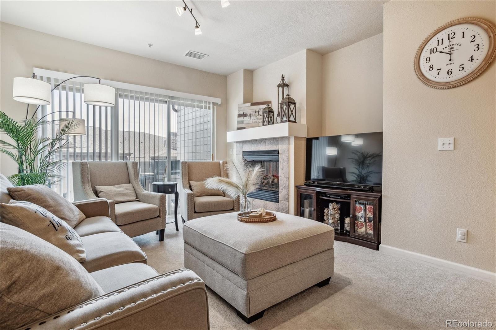 9370 Las Ramblas Court, Unit R Parker, CO 80134 - Photo 33 of 39 a living room with furniture a flat screen tv and a fireplace