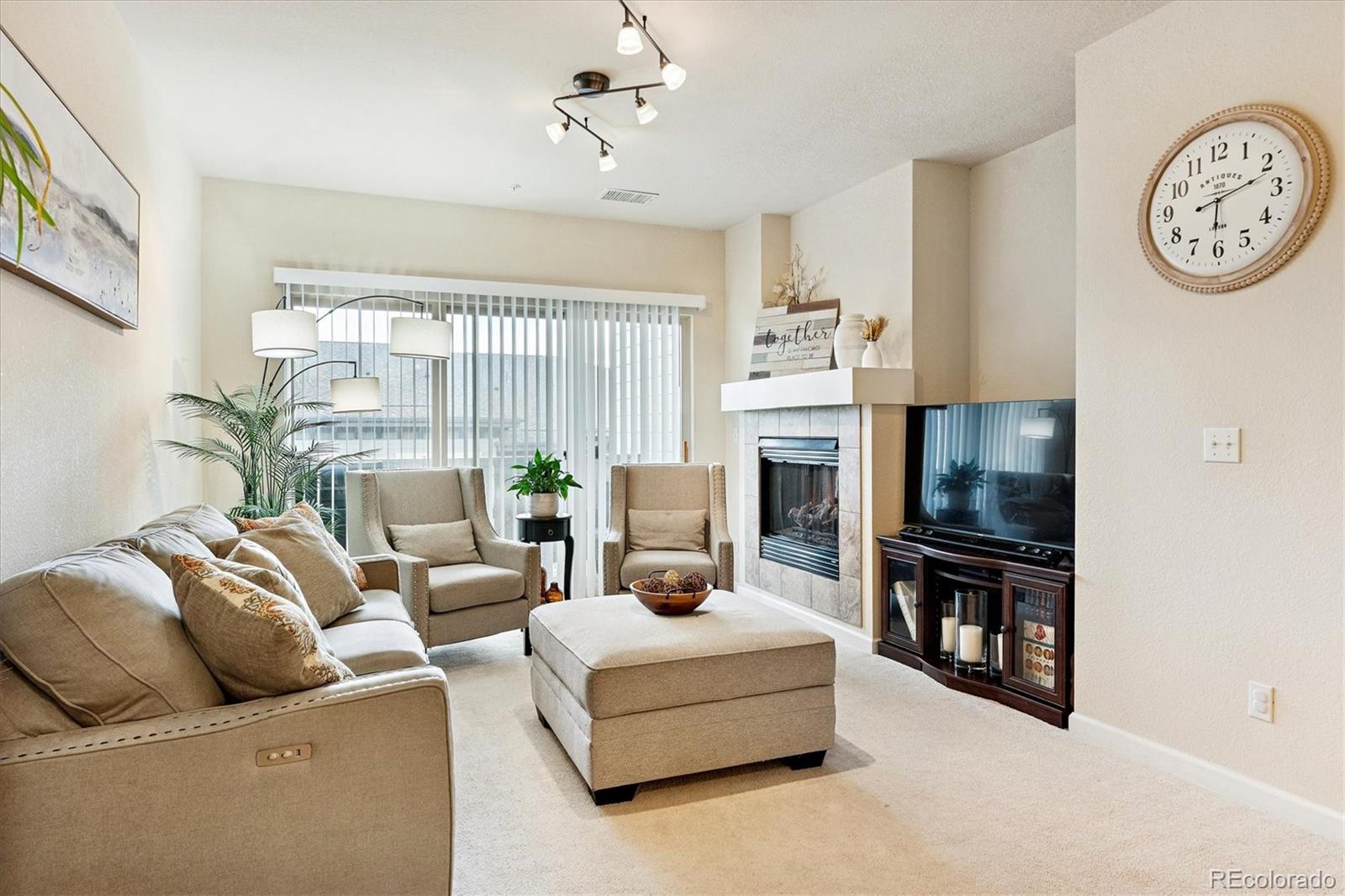 9370 Las Ramblas Court, Unit R Parker, CO 80134 - Photo 4 of 39 a living room with furniture a fireplace and a large window
