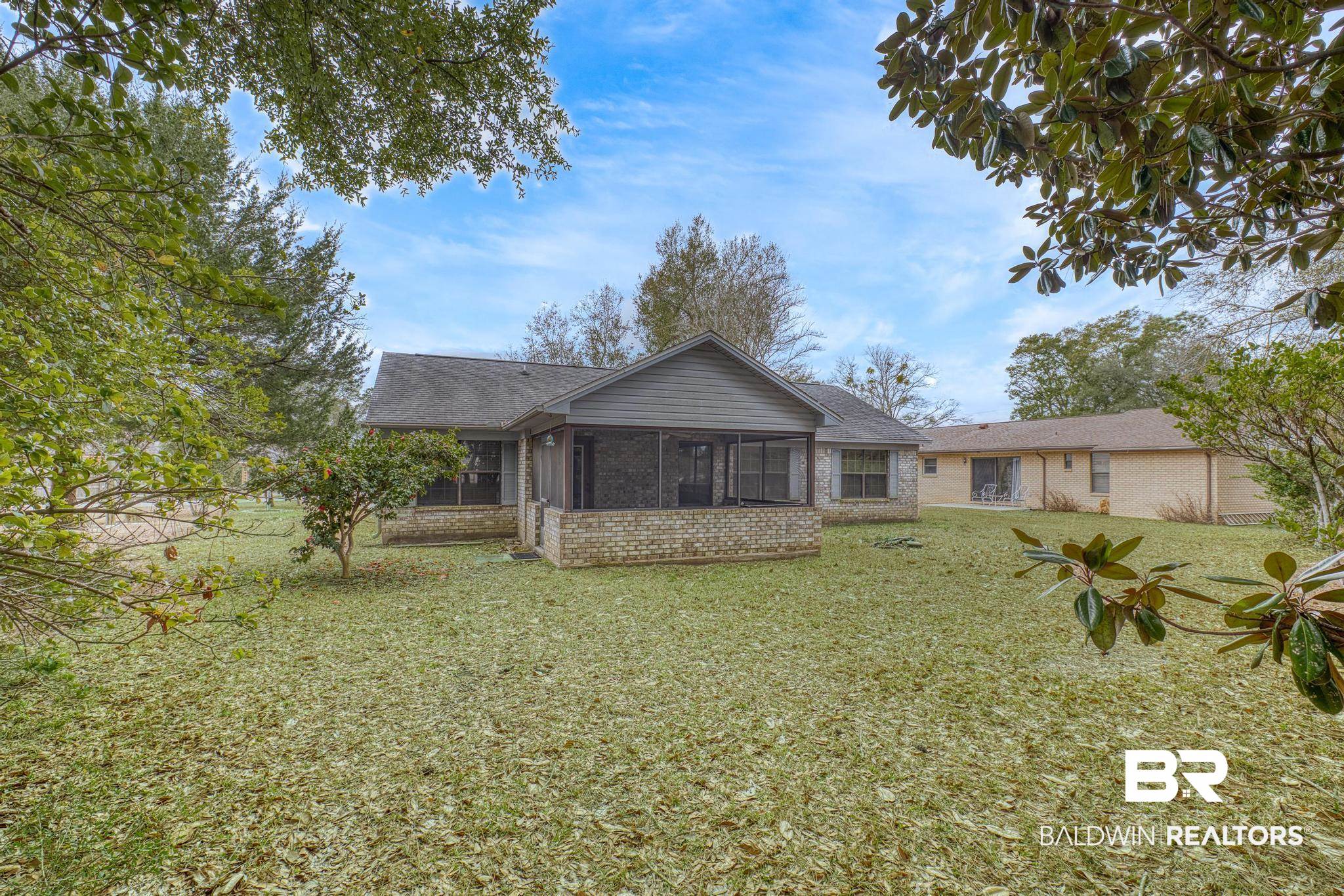 2776 Santa Rosa Circle Lillian, AL 36549 - Photo 2 of 48 Rear view of property featuring a sunroom, a lawn, a shingled roof, and brick siding
