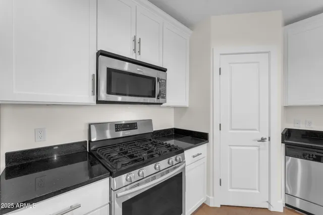 a kitchen with microwave cabinets and stove top oven