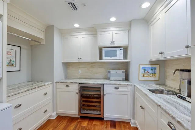 a view of a hallway with wooden floor and furniture