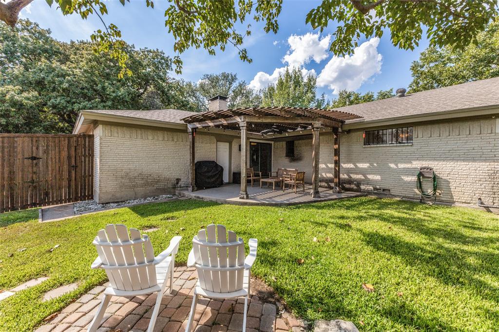 9864 Shoreview Road Dallas, TX 75238 - Photo 21 of 24 Expansive backyard featuring a manicured lawn, brick paver patio, wood pergola, and full privacy fencing