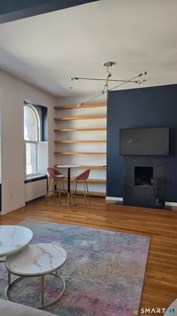 a view of an empty room with a fireplace and a chandelier