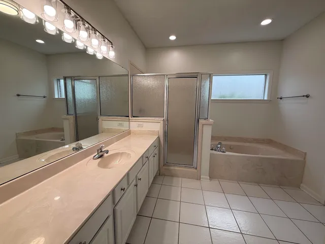 a bathroom with a tub sink and mirror