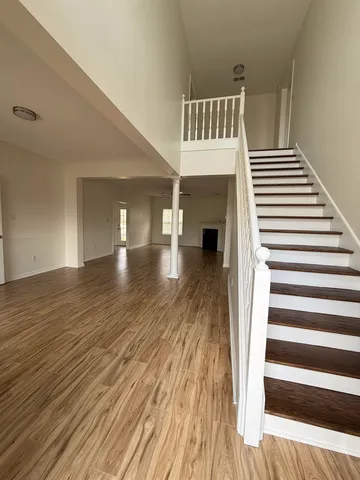 a view of a livingroom with wooden floor and staircase