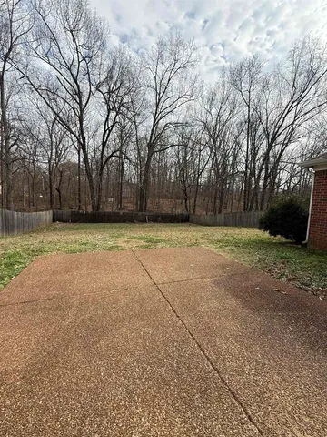 a view of a tennis ground with trees in the background