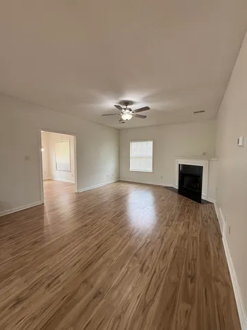 a view of empty room with window and wooden floor