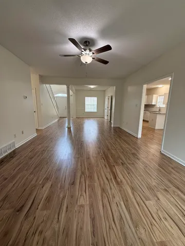 a view of empty room with wooden floor