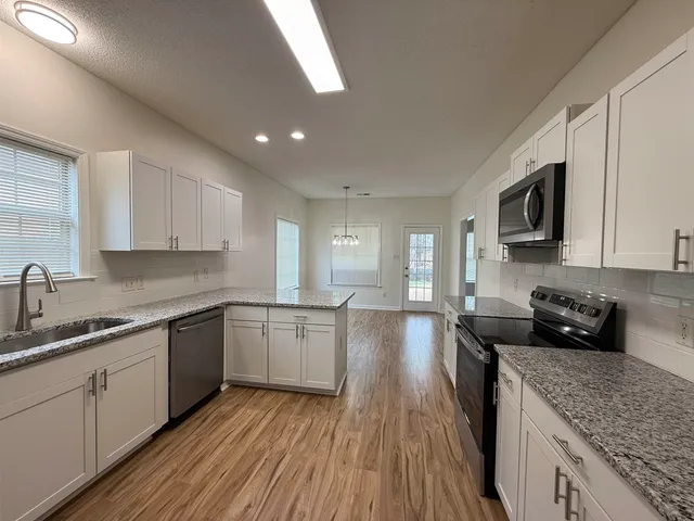 a kitchen with sink stove top oven and refrigerator