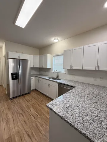 a kitchen with stainless steel appliances granite countertop a sink dishwasher stove top oven and refrigerator
