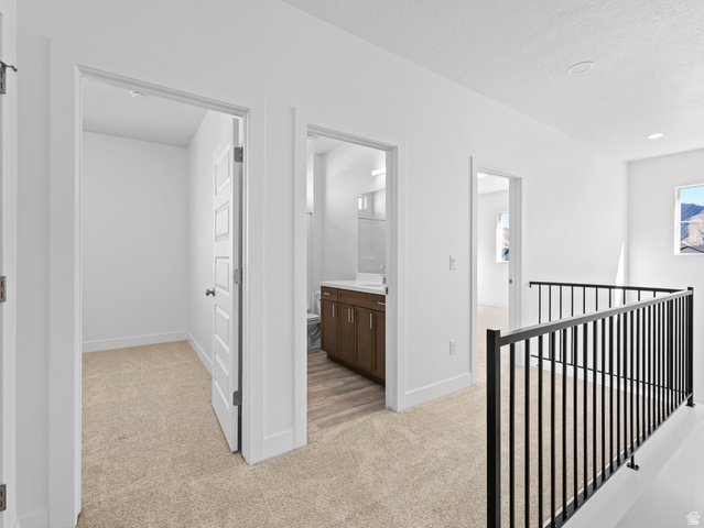 18 South Crimson Way, Unit 304 Mapleton, UT 84664 - Photo 12 of 17 Hallway featuring light colored carpet and an upstairs landing