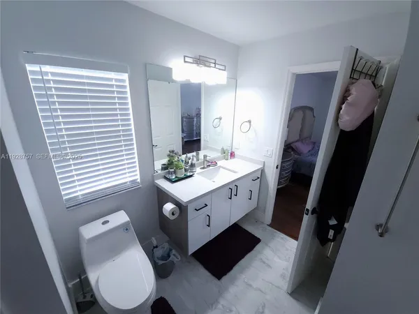 a bathroom with a sink a toilet a mirror and shower