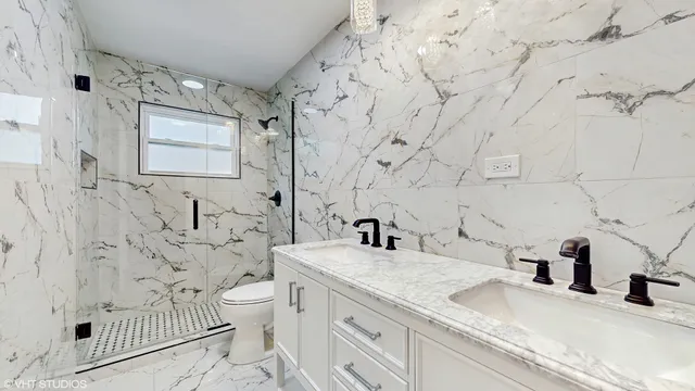 a bathroom with a granite countertop sink a toilet and a shower
