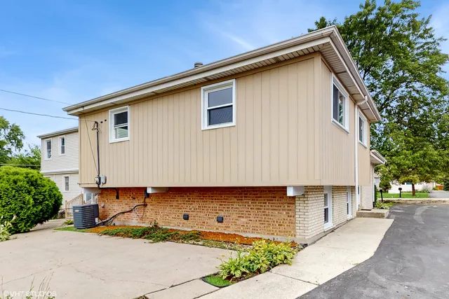 a backyard of a house with large trees and parked area