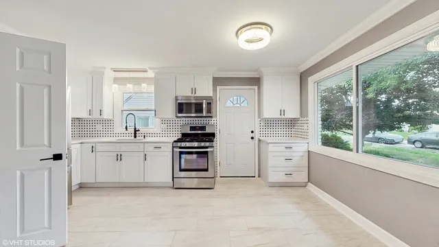 a kitchen with white cabinets and appliances