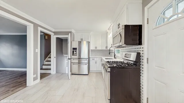 a kitchen with a refrigerator and a stove top oven