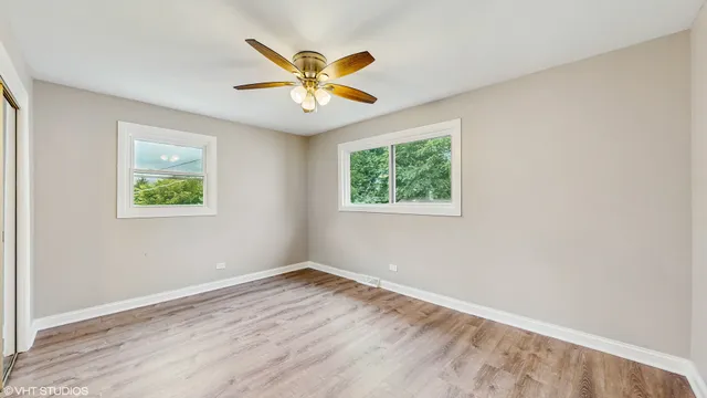 a view of a big room with wooden floor and windows
