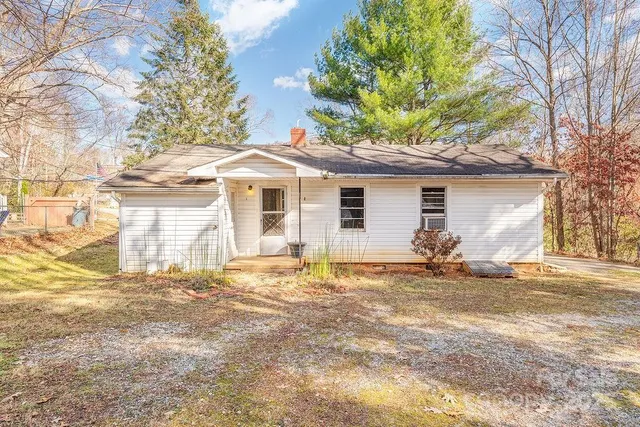 a view of a yard with a house and a large tree