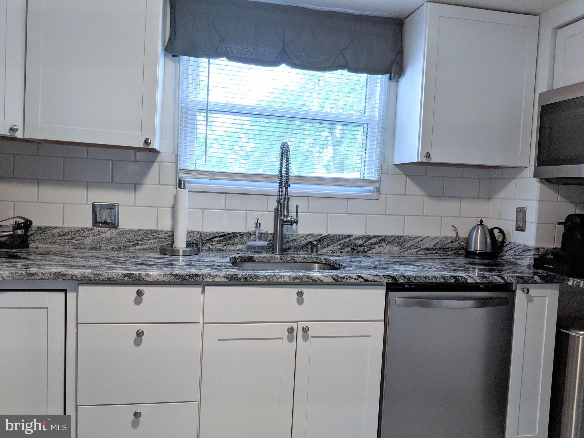 2795 York Rd. Jamison, PA 18929 - Photo 25 of 39 a kitchen with granite countertop white cabinets and a window