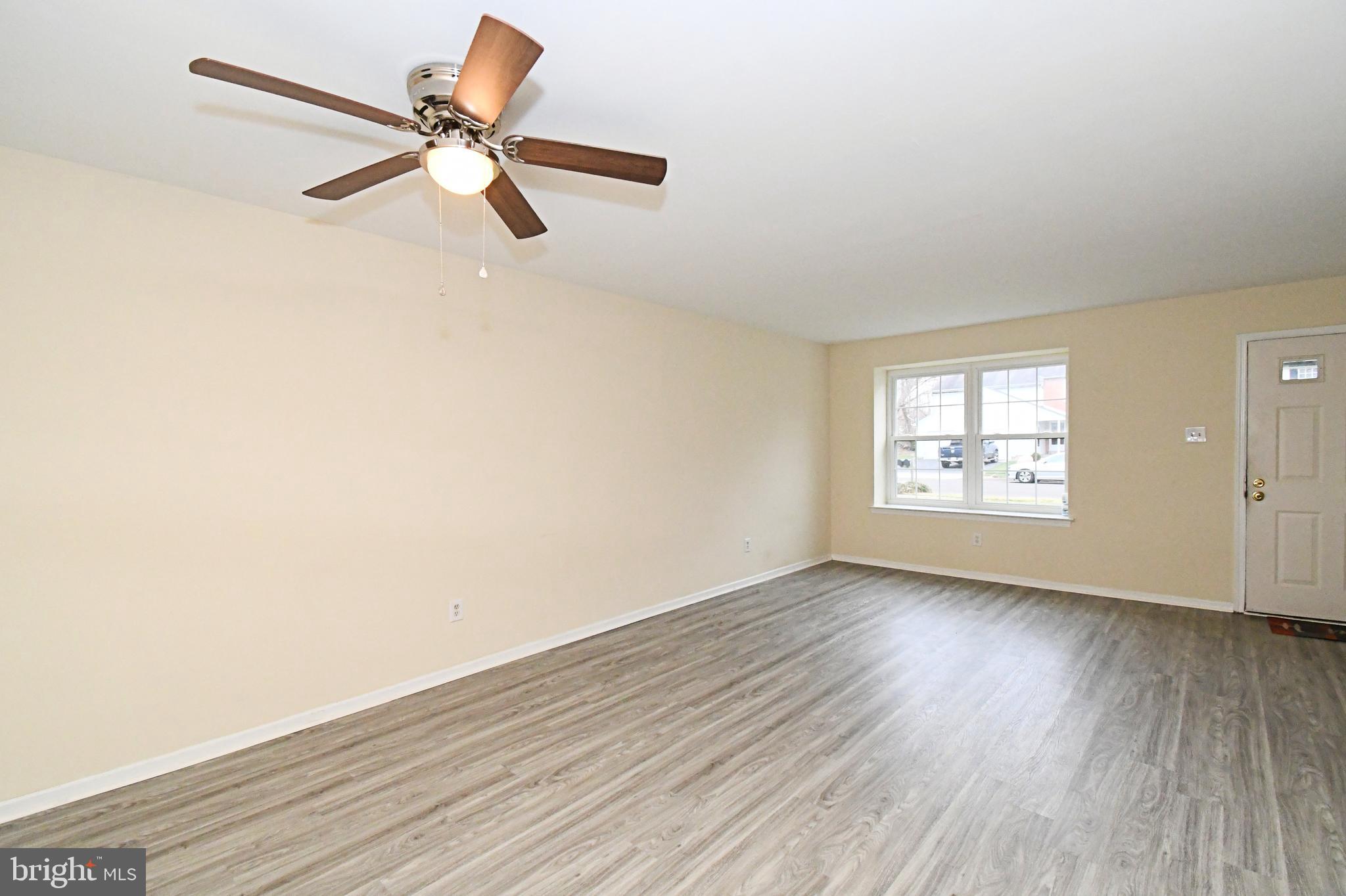 592 A Wrensong Road, Unit A Yardley, PA 19067 - Photo 4 of 36 an empty room with wooden floor fan and windows