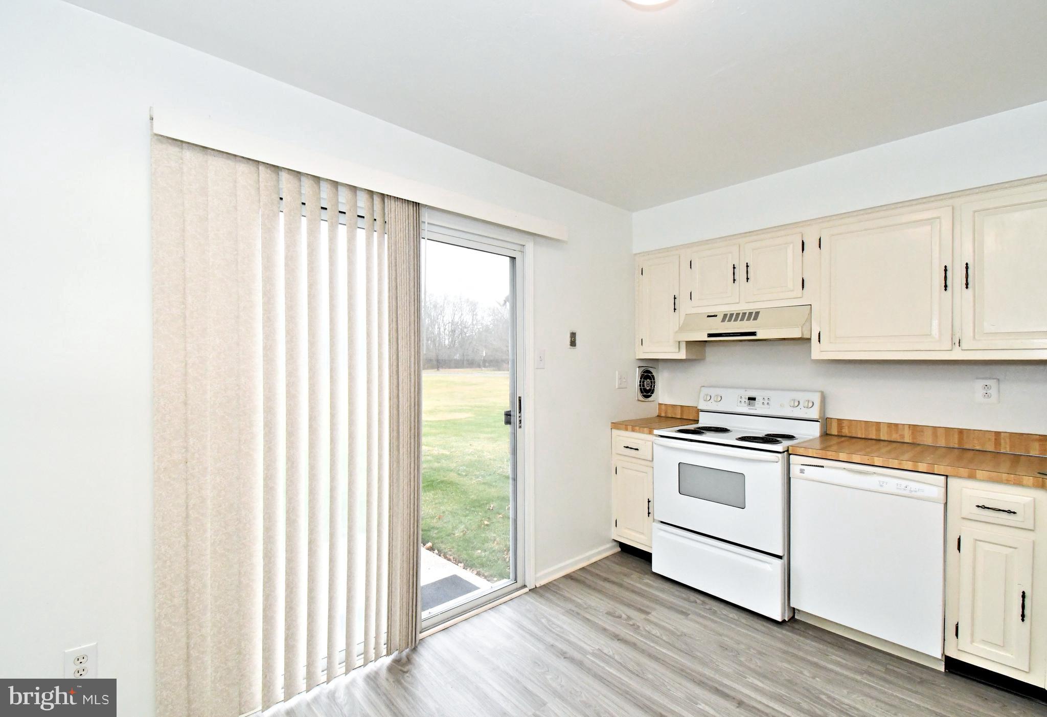 592 A Wrensong Road, Unit A Yardley, PA 19067 - Photo 5 of 36 a kitchen with stainless steel appliances granite countertop a stove a sink and white cabinets with wooden floors