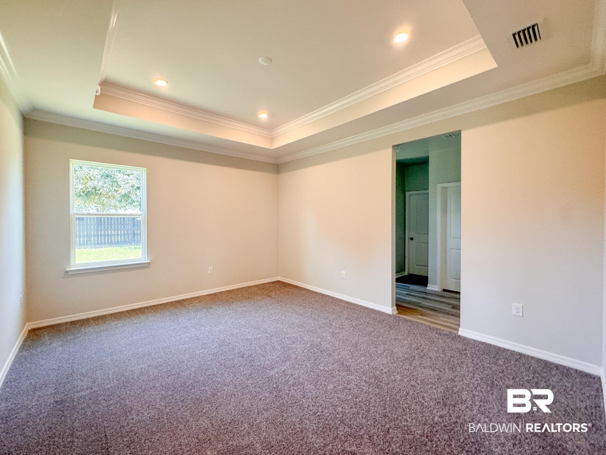 23939 Dominus Drive Daphne, AL 36526 - Photo 5 of 9 Carpeted spare room with crown molding, a tray ceiling, and recessed lighting