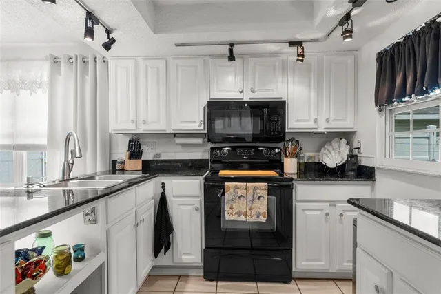 a kitchen with stainless steel appliances granite countertop a stove top oven a sink dishwasher and a refrigerator