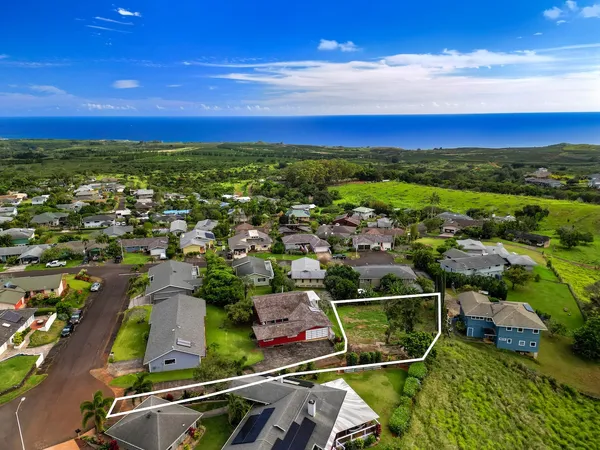 an aerial view of residential houses with outdoor space and ocean view