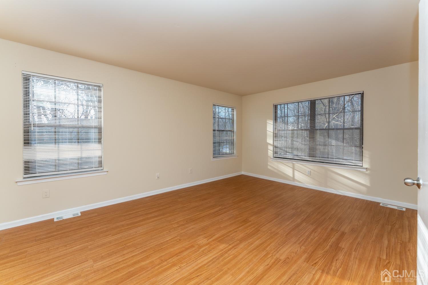 3204 Stonehedge Road Edison, NJ 08820 - Photo 20 of 22 a view of an empty room with wooden floor and a window