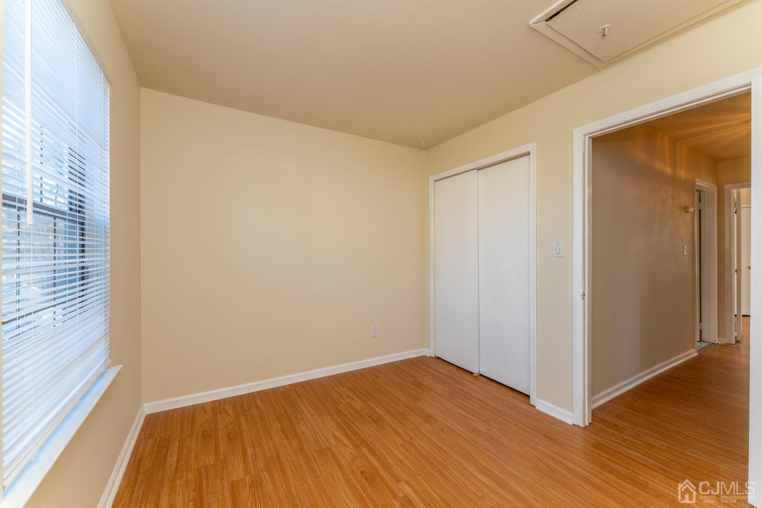 3204 Stonehedge Road Edison, NJ 08820 - Photo 21 of 22 a view of an empty room with wooden floor and a window