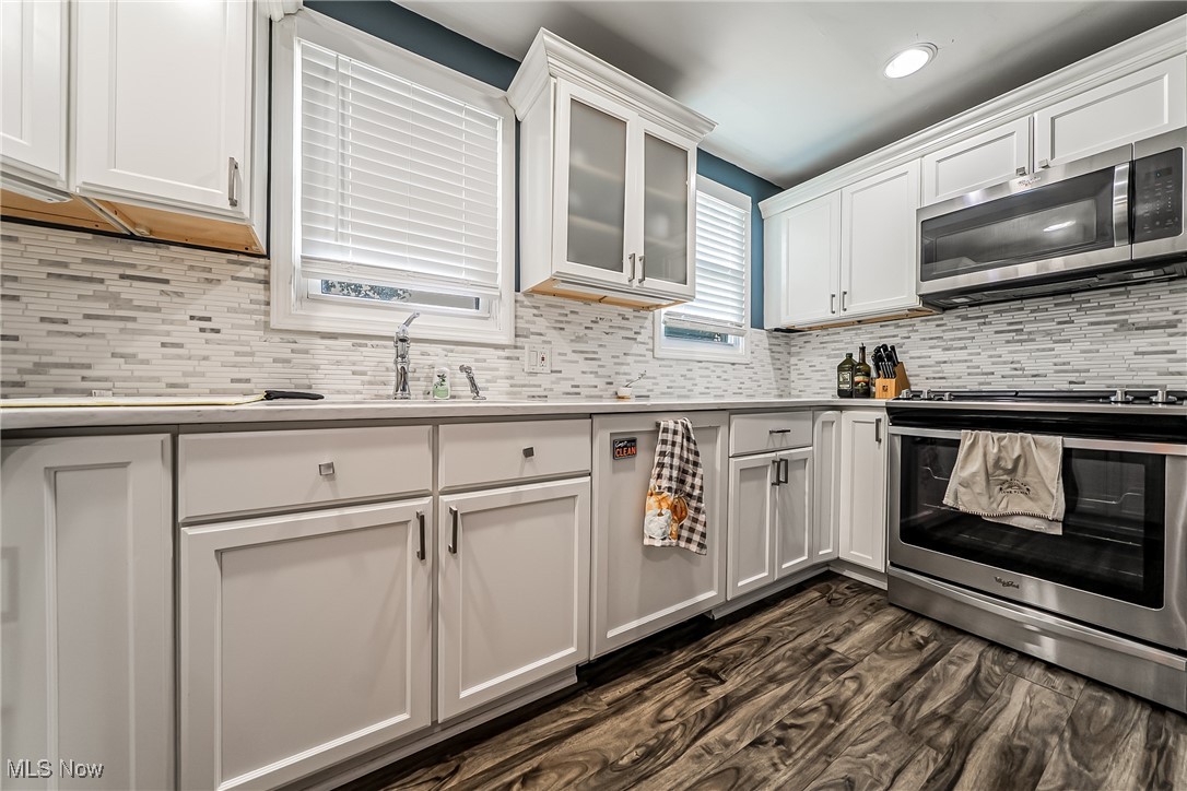 1235 Dorsh Road Cleveland, OH 44121 - Photo 10 of 39 Kitchen with appliances with stainless steel finishes, white cabinets, tasteful backsplash, light countertops, and recessed lighting