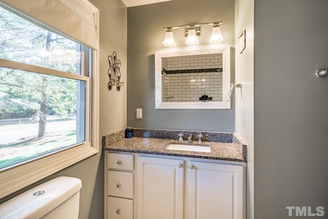 1105 Somerset Road Raleigh, NC 27610 - Photo 11 of 19 a bathroom with a granite countertop sink and a large mirror