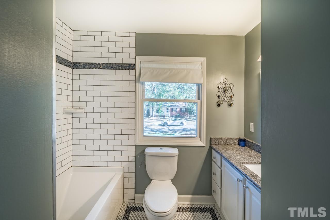 1105 Somerset Road Raleigh, NC 27610 - Photo 12 of 19 a bathroom with a granite countertop toilet a sink and bathtub