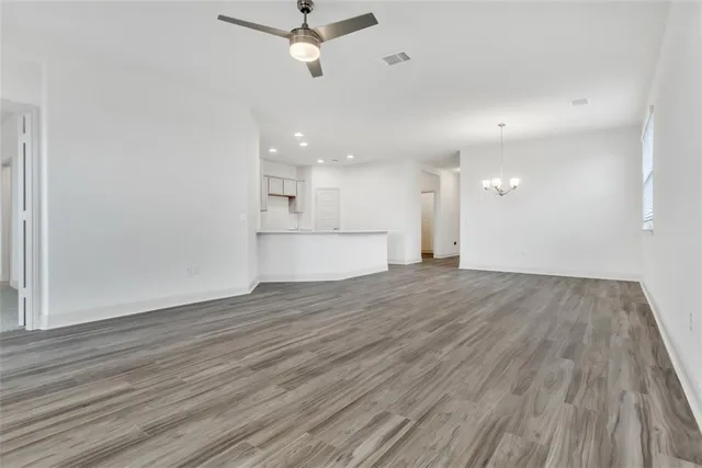 wooden floor in an empty room with a kitchen
