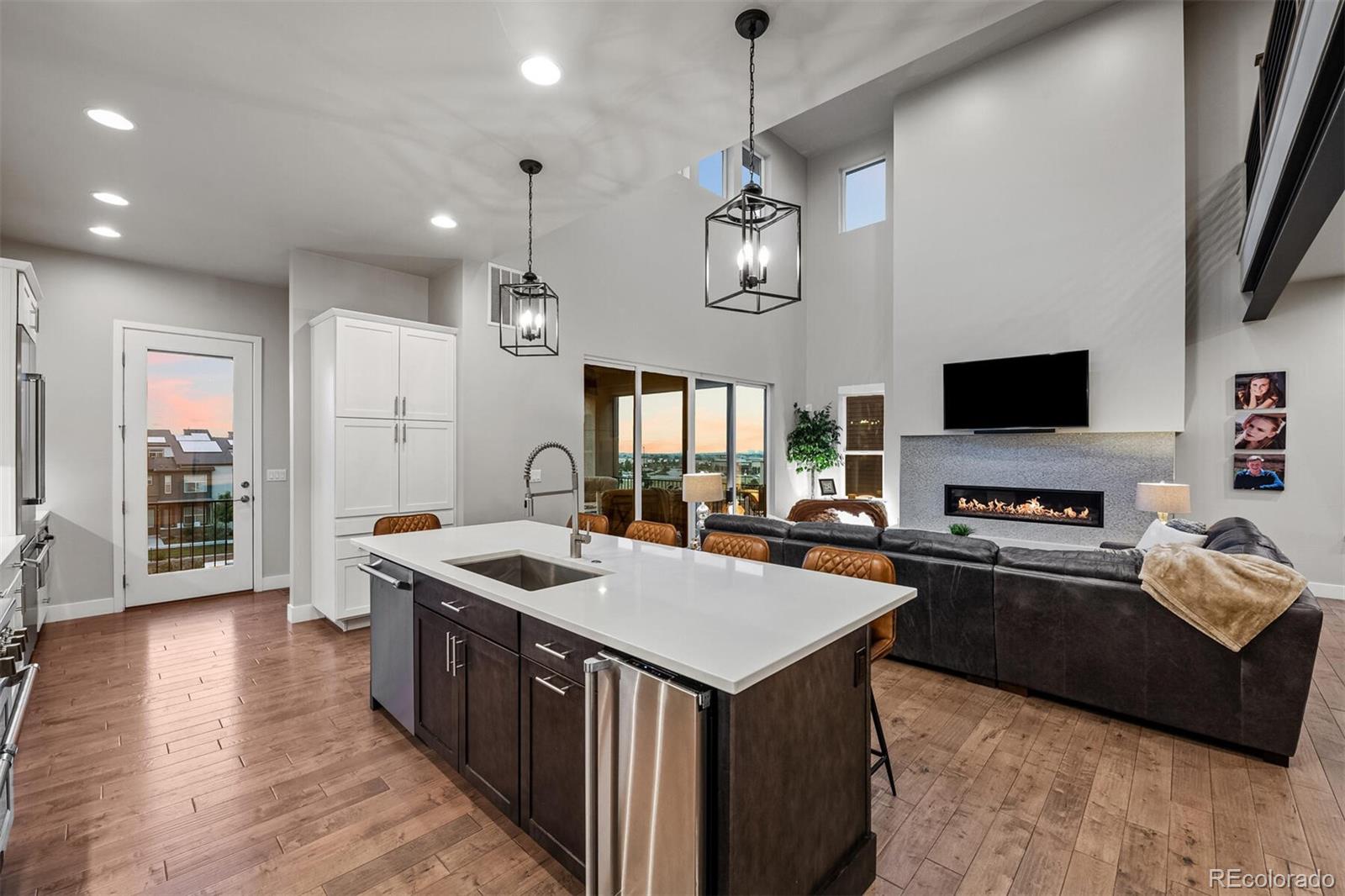10109 Bellwether Lane Lone Tree, CO 80124 - Photo 13 of 40 a kitchen with a stove a sink a kitchen island with chairs and wooden floor