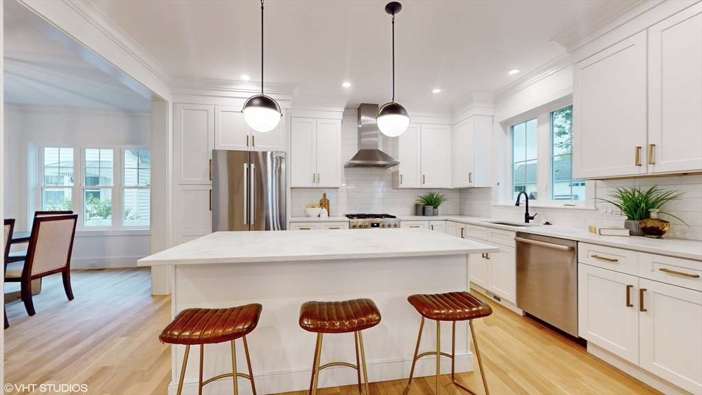 49 Ledge Hill Road Boston, MA 02132 - Photo 10 of 34 a kitchen with stainless steel appliances kitchen island a table and chairs in it