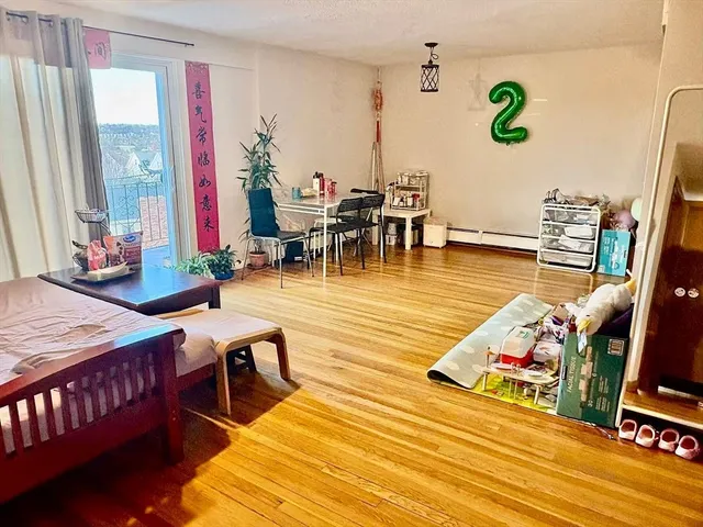 a living room with dining room and wooden floor