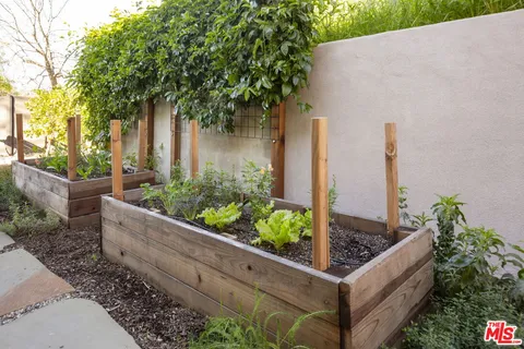 a front view of a house with a yard and potted plants