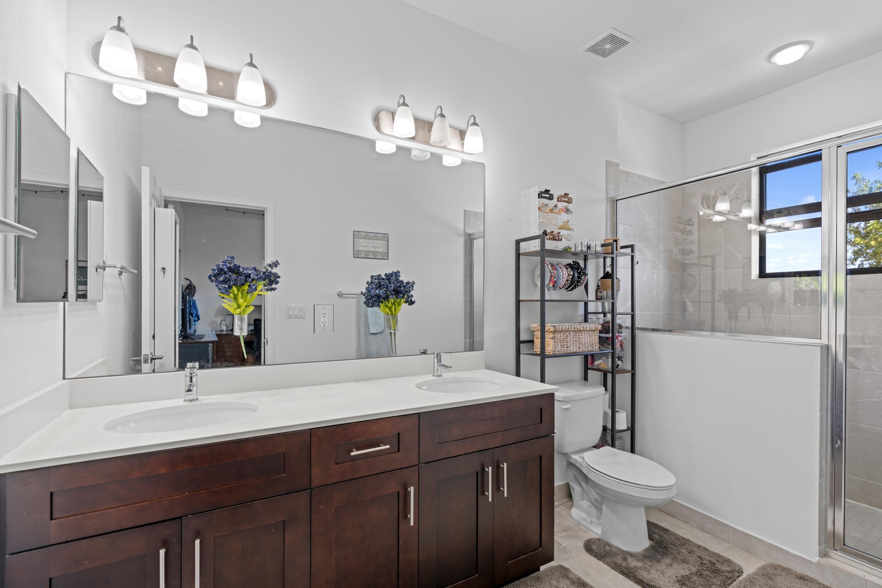 3006 Hoptree Way Riviera Beach, FL 33410 - Photo 15 of 35 a bathroom with a sink vanity granite toilet and a mirror