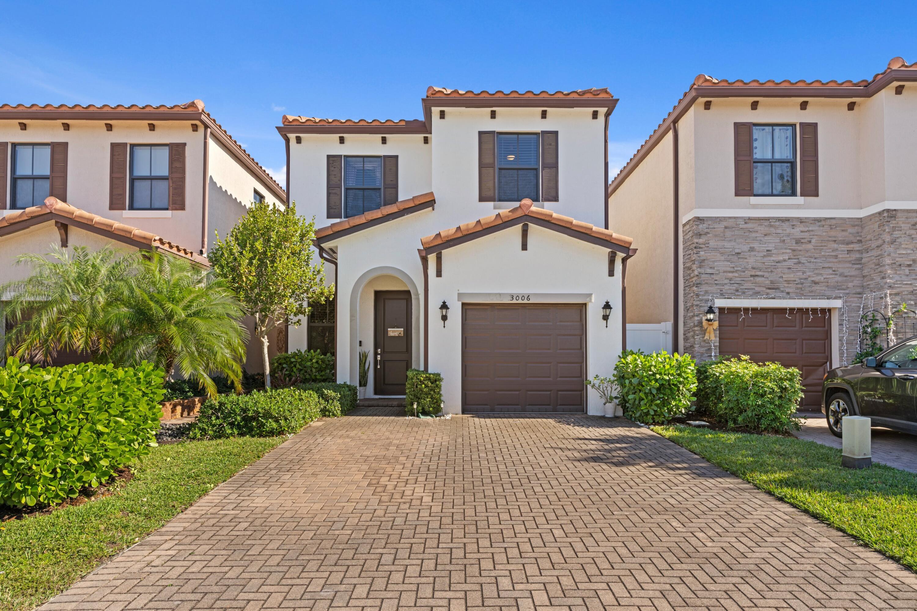 3006 Hoptree Way Riviera Beach, FL 33410 - Photo 2 of 35 a view of a white house with a small yard and plants