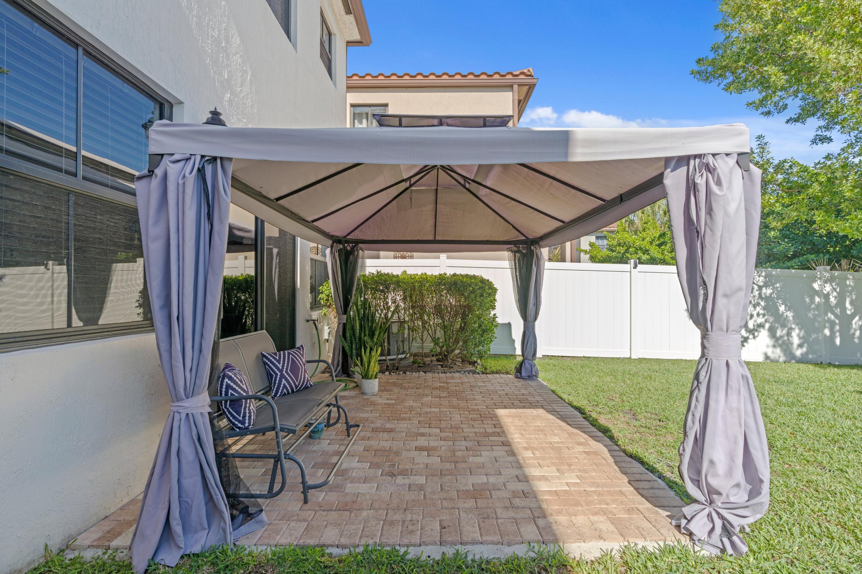 3006 Hoptree Way Riviera Beach, FL 33410 - Photo 21 of 35 a patio with a yard table and chairs