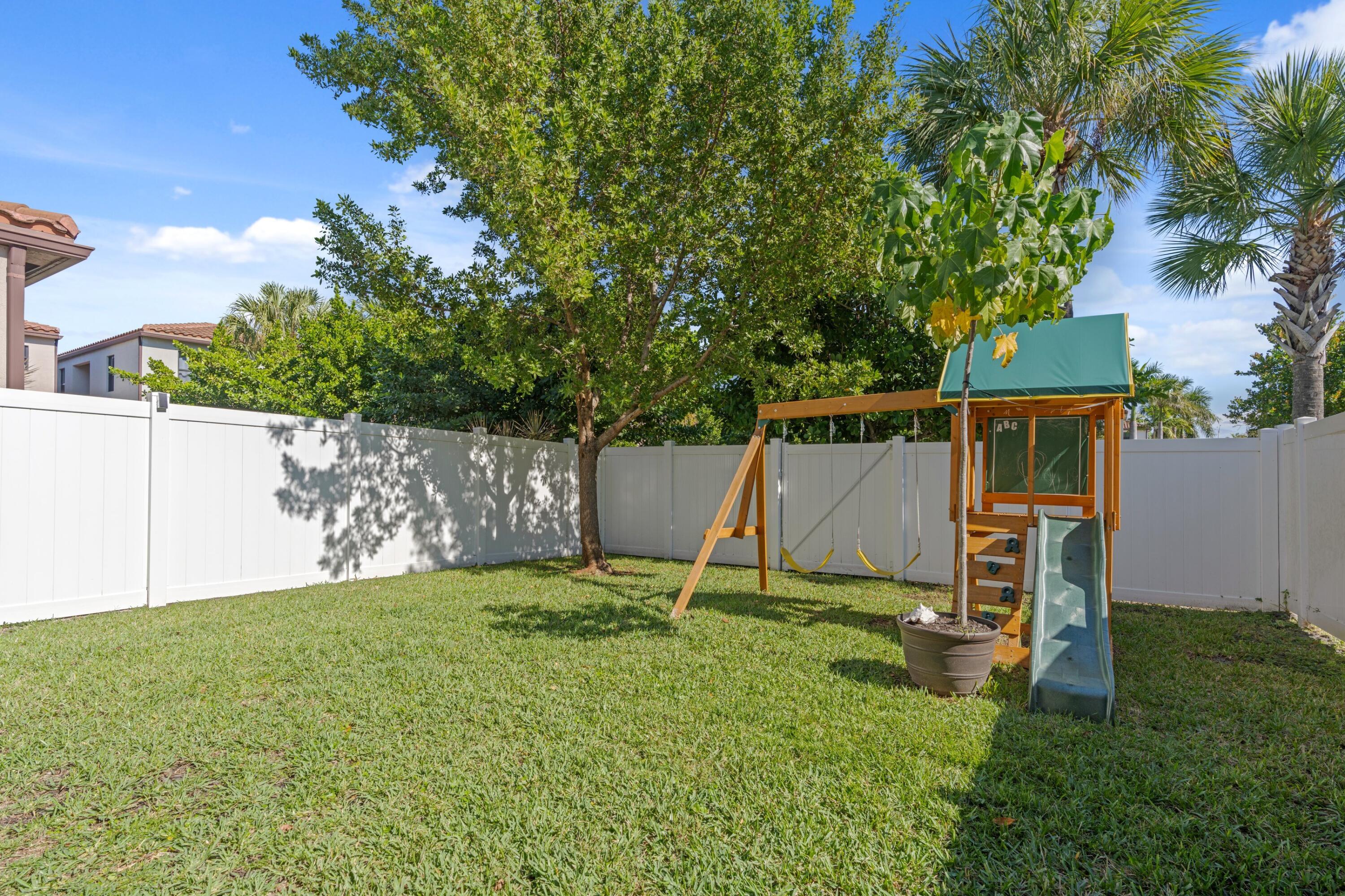 3006 Hoptree Way Riviera Beach, FL 33410 - Photo 24 of 35 a backyard of a house with table and chairs