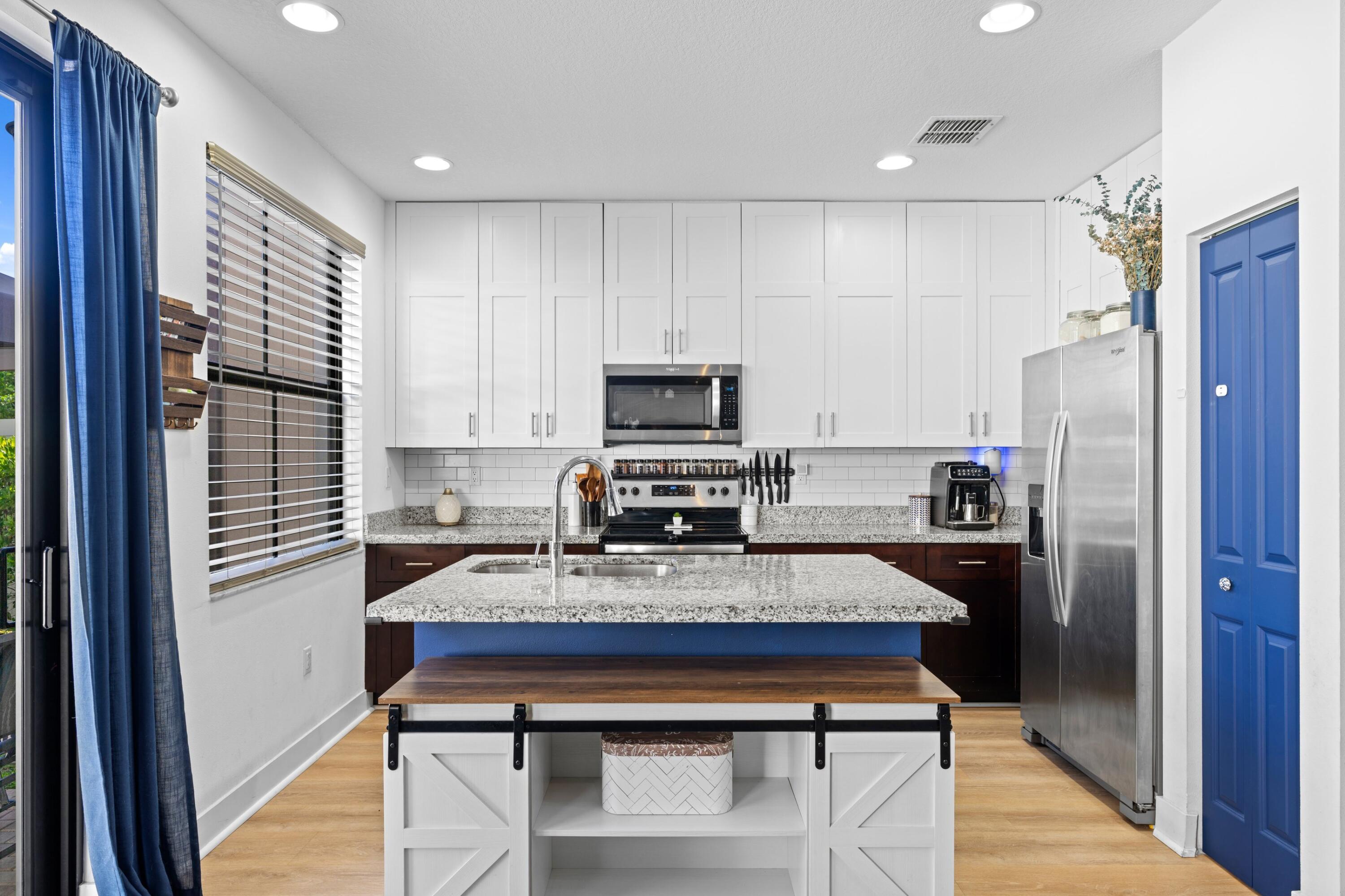 3006 Hoptree Way Riviera Beach, FL 33410 - Photo 8 of 35 a kitchen with kitchen island white cabinets and stainless steel appliances