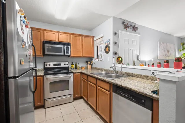a kitchen with stainless steel appliances granite countertop a sink stove and microwave